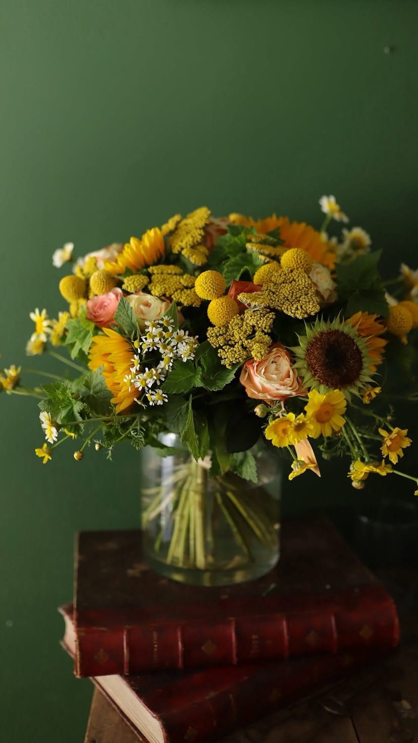 Bouquet jaune de saison dans un vase, sur fond vert