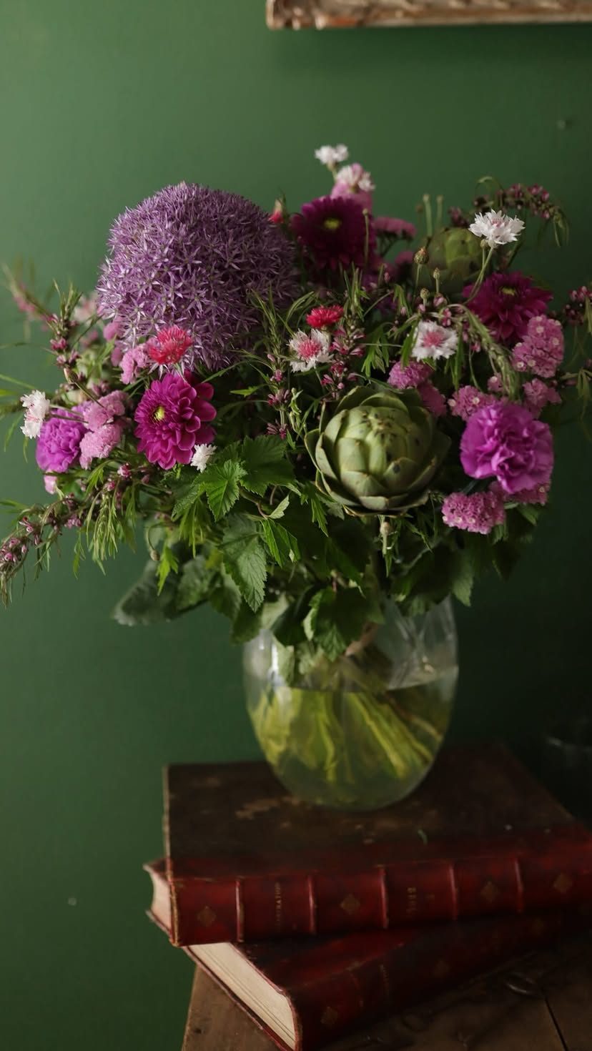 Bouquet mauve et vert dans un vase, sur fond vert