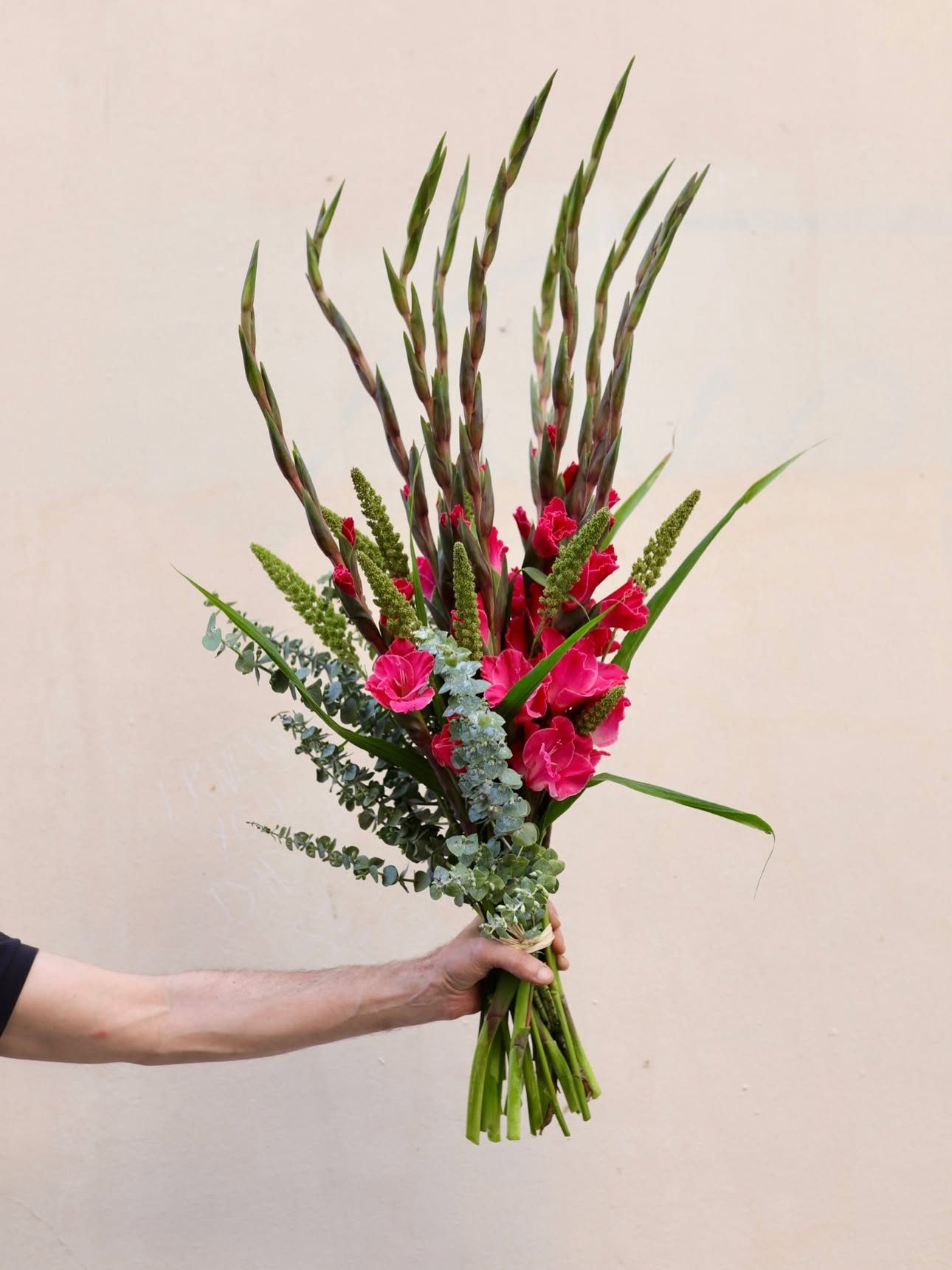 Glaïeuls et graminées, bouquet d’été tenu à la main
